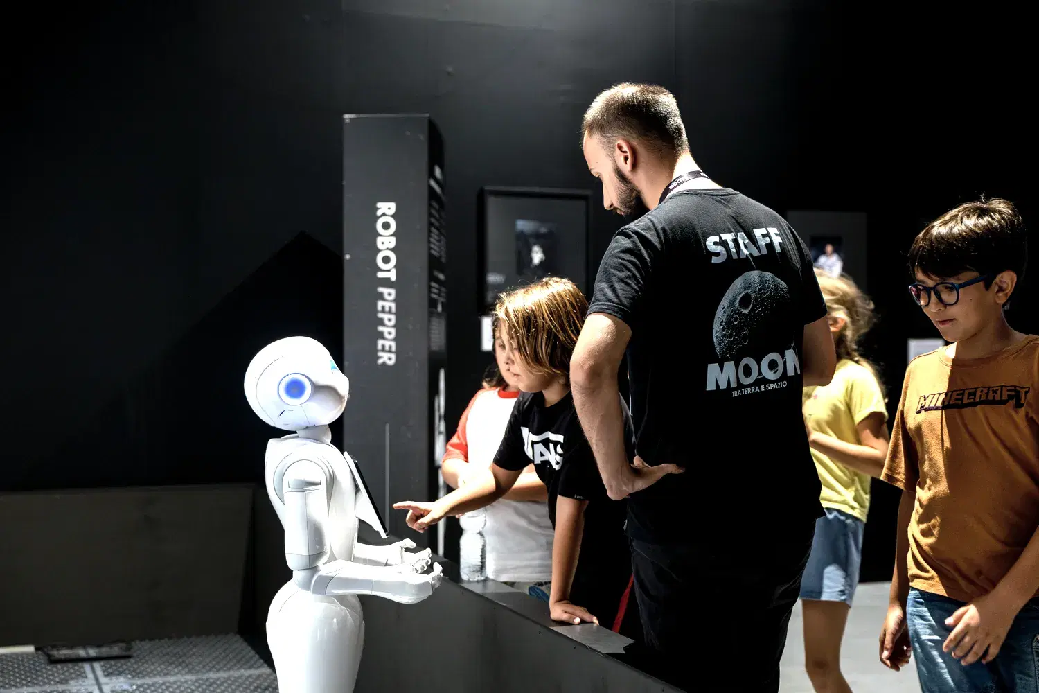 The exhibition's white humanoid robot gestures in front of a visitor listening to it