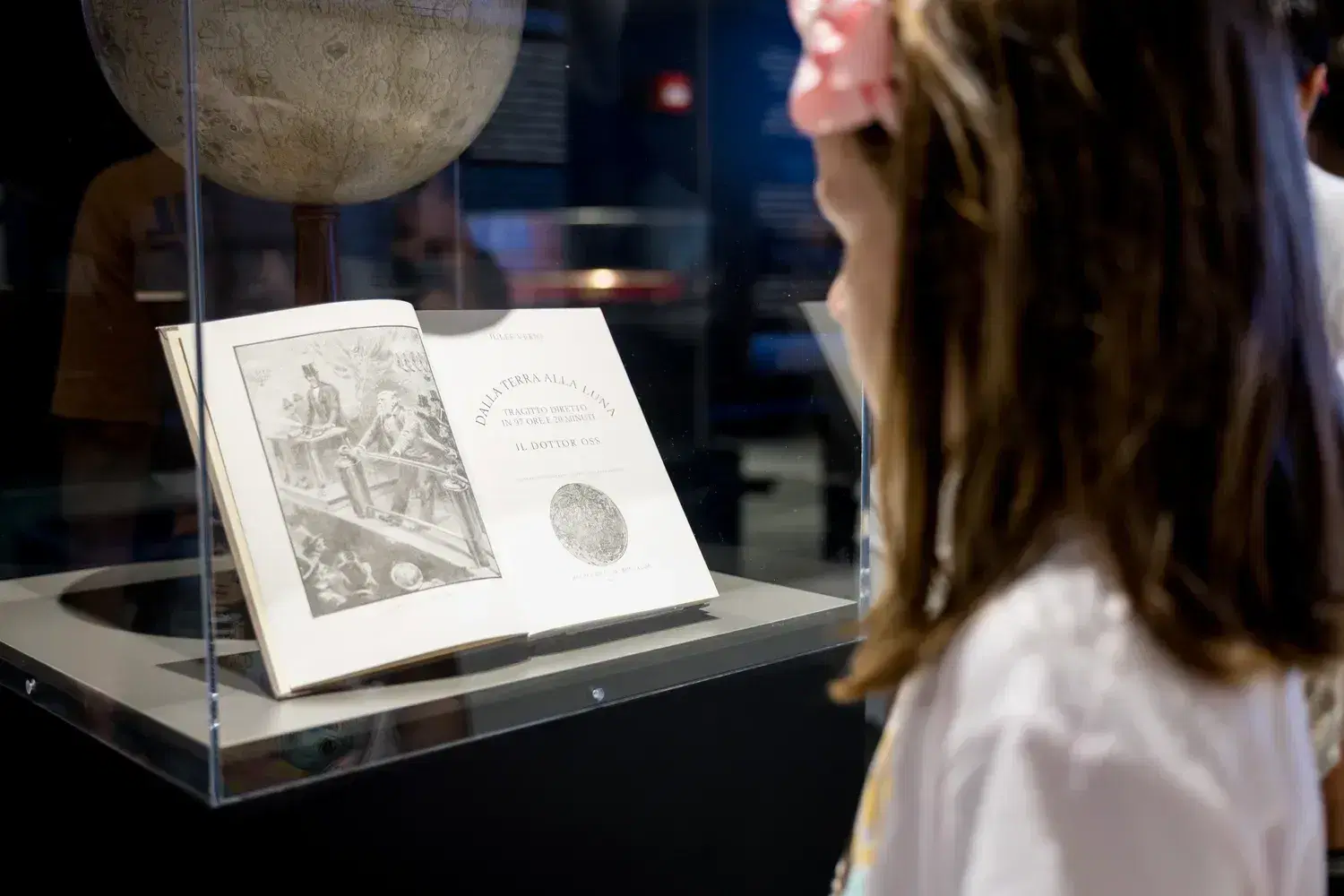 A girl looks at the case with Galileo's Sidereus Nuncius lying open