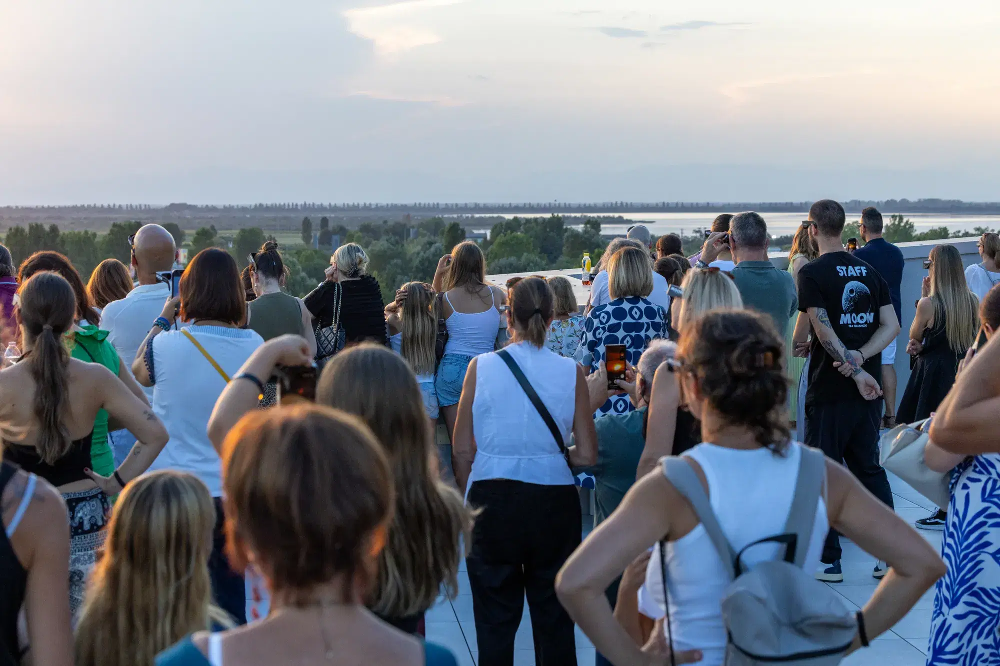 Il pubblico sulla terrazza del JMuseo guarda verso la laguna mentre il Sole tramonta