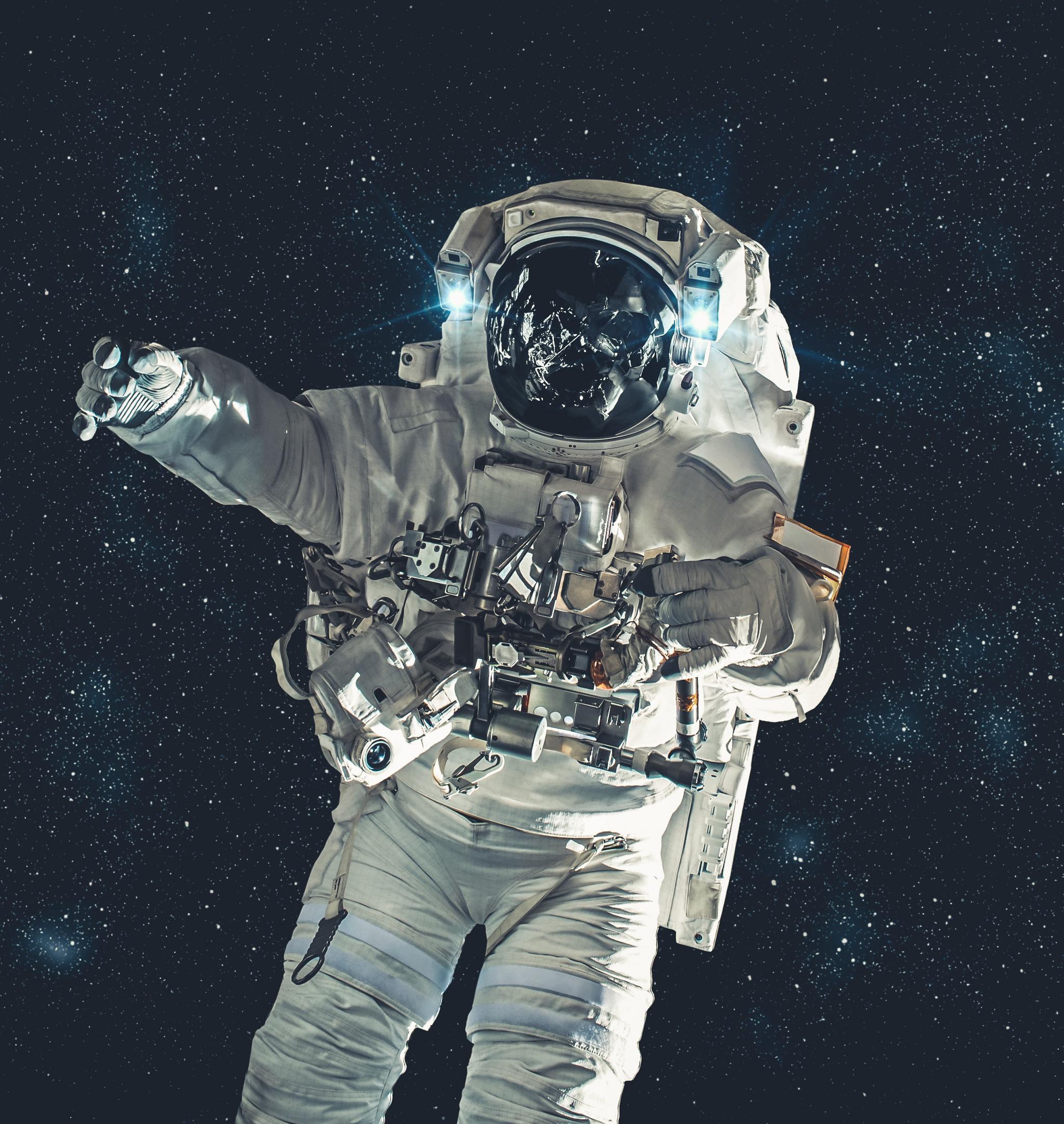 Un astronauta in tuta durante una passeggiata spaziale, su fondo di stelle